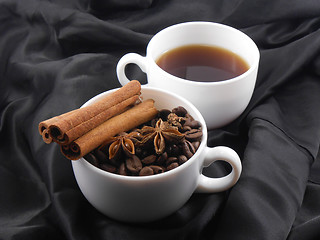 Image showing white cup of tea, coffee beans, cinnamon and star anise
