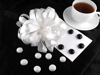 Image showing hot cup of tea with gift bow ribbon and stones