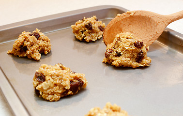 Image showing Cookie dough being spooned onto baking sheet