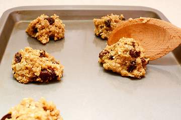 Image showing Spooning oatmeal raisin cookie dough onto a baking sheet