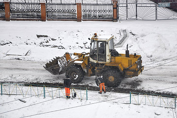 Image showing Special equipment on road construction. Snowfall.