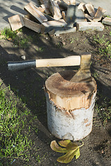 Image showing Ax chopping wood on chopping block