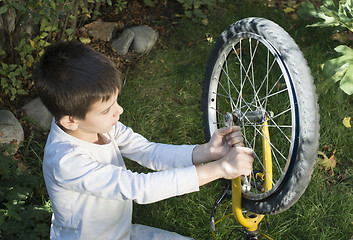 Image showing Kid who fix bikes