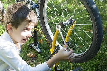 Image showing Kid who fix bikes