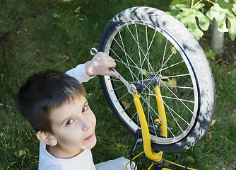 Image showing Kid who fix bikes