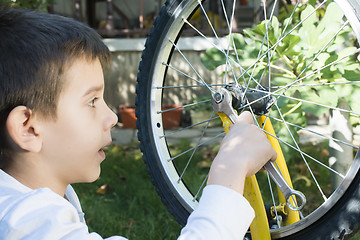 Image showing Kid who fix bikes