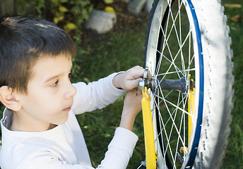 Image showing Kid who fix bikes