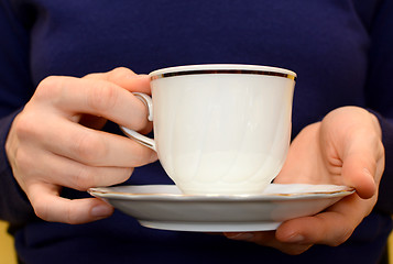 Image showing Closeup of a woman's hands holding a teacup and saucer