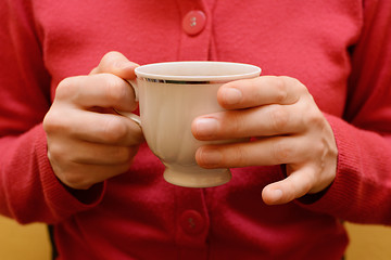 Image showing Woman holding a teacup in two hands