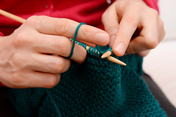 Image showing Closeup of woman knitting with teal wool