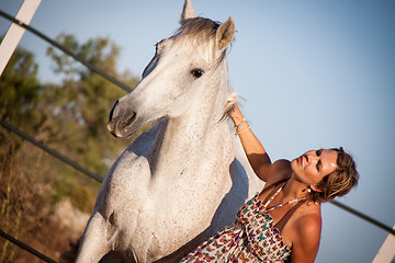 Image showing young woman walking a road with horse