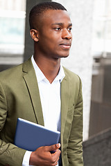 Image showing smiling successful businessman with tablet pc outdoor