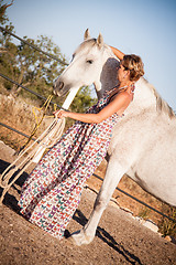 Image showing young woman walking a road with horse