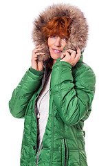 Image showing redhead smiling adult mature woman with geen warm jacket