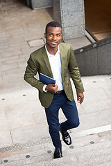 Image showing smiling successful businessman with tablet pc outdoor