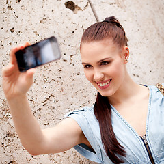 Image showing attractive young woman with smartphone camera photos outdoor