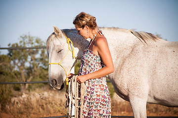 Image showing young woman walking a road with horse