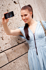 Image showing attractive young woman with smartphone camera photos outdoor