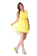 Image showing smiling young brunette woman in yellow dress isolated