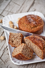 Image showing sliced fresh buns, old knife and hazelnuts 