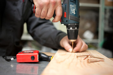 Image showing Man with screwdriver. Focused on screw in front