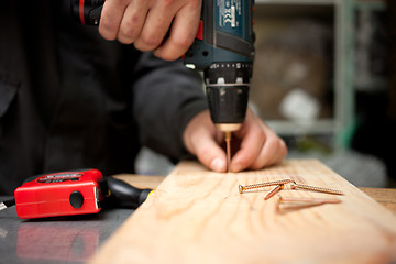 Image showing Man with screwdriver. Focused on screw in front