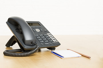 Image showing phone on desk with notepad on wooden desk