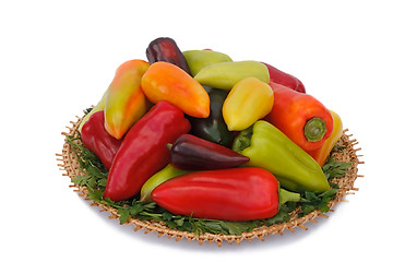 Image showing Red, yellow and green peppers on the wicker dish on a white back