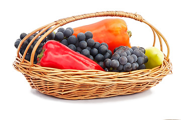 Image showing Red, yellow pepper and grapes in a wicker basket on a white back