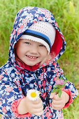 Image showing Portrait of a little girl with wild flowers in the hands  