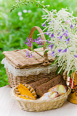 Image showing Buns in a wicker basket and a bouquet of field flowers  