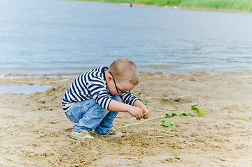 Image showing  Boy and girl playing in the sand on the shore of Lake 