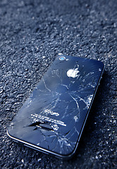 Image showing Black iPhone  with broken display laying on asphalt