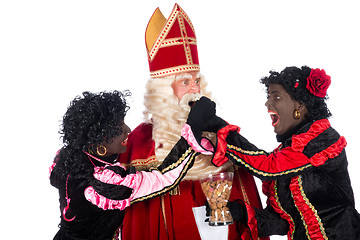 Image showing Zwarte Piet giving pepernoten (cookies) to Sinterklaas