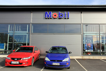 Image showing Two Cars in front of a Shop with Mobil Sign