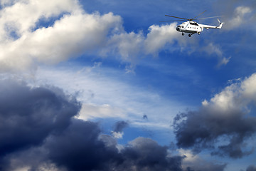 Image showing Helicopter in blue sky with clouds