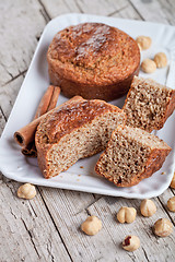 Image showing sliced fresh buns, hazelnuts and cinnamon 