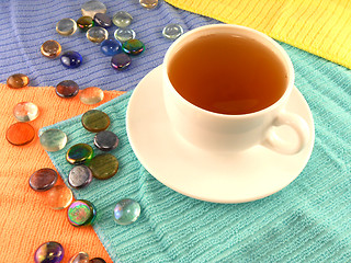 Image showing Outdoor cup of tea in a white cup with stones on a material background