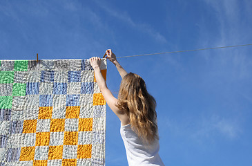 Image showing Longhaired girl and bright laundry