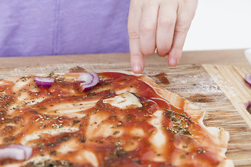 Image showing hand making fresh pizza on wooden board