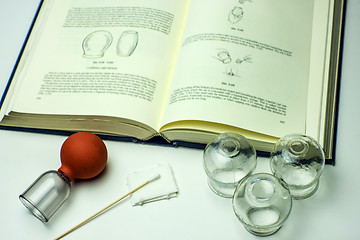 Image showing Cupping glasses with textbook