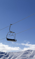 Image showing Chair lift and snowy mountains at nice day