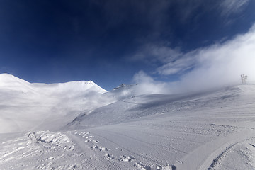 Image showing Ski slope with snowmobile trail