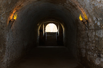 Image showing catacombs of the old castle illuminated burning torches