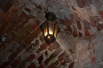 Image showing Old red bricks wall and light hanging on the wall