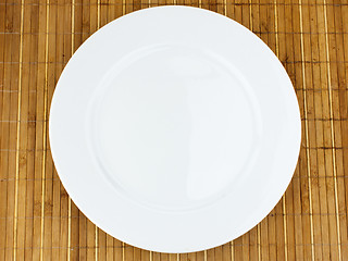 Image showing white plate on a bamboo napkin
