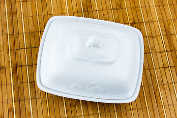 Image showing oval dish for butter on a bamboo napkin