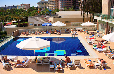 Image showing sunbathing by the pool