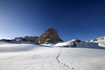 Image showing Snowy plateau and footpath against rock and blue sky in nice day