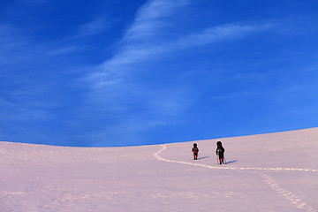 Image showing Two hikers on sunrise snowy plateau